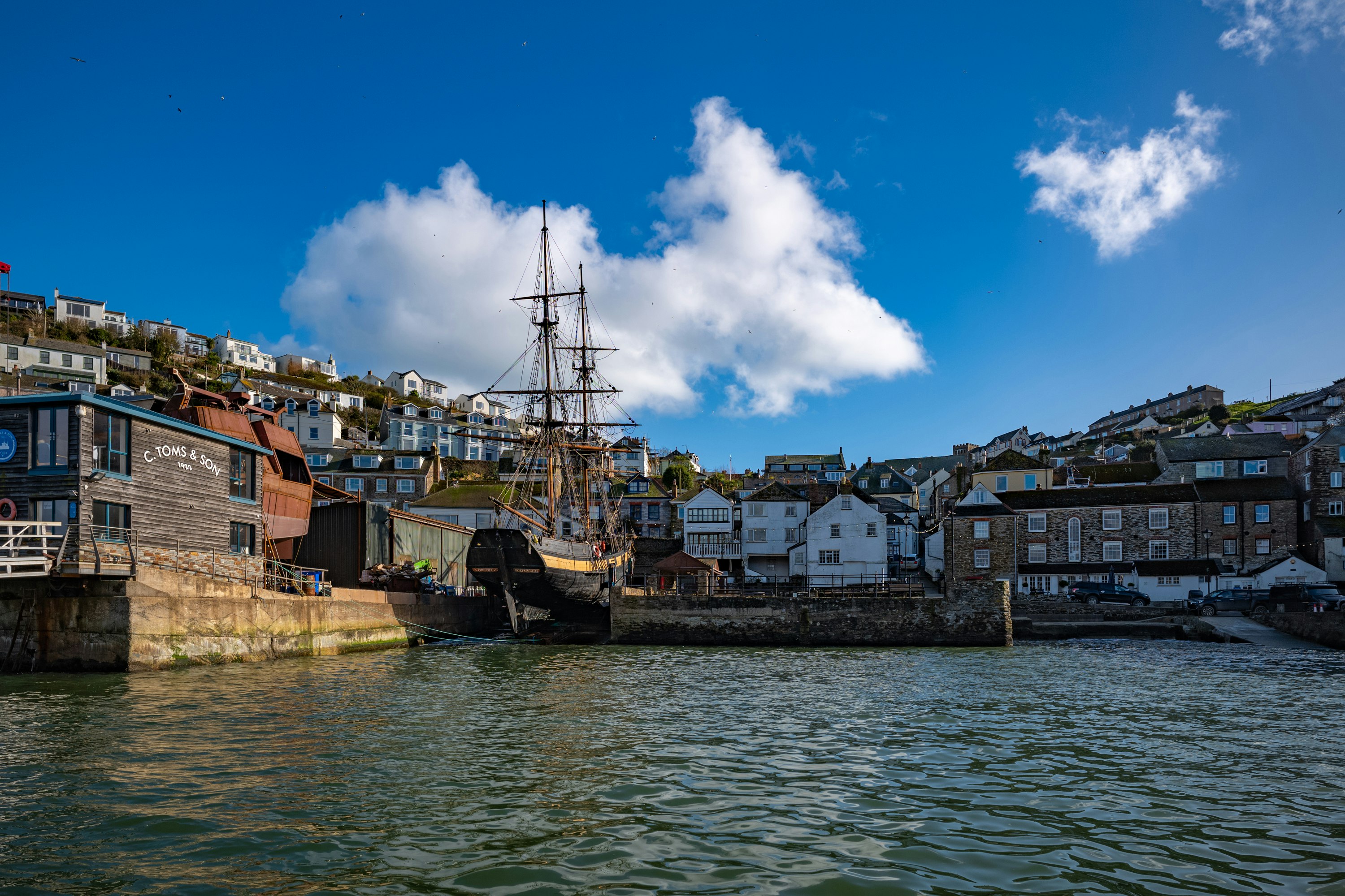 brown and white concrete buildings beside body of water under blue sky during daytime